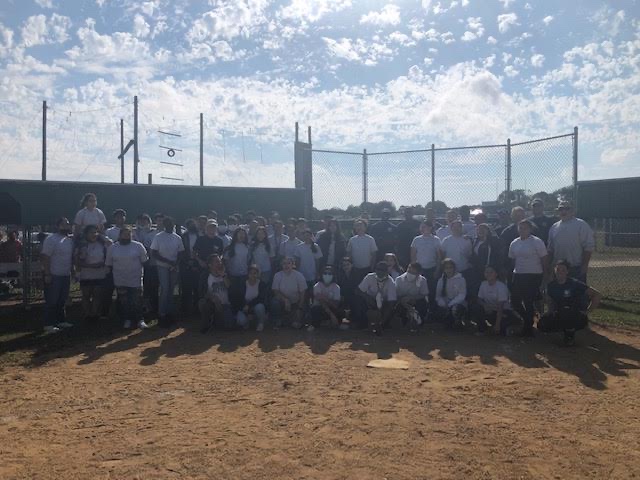 The AFJROTC cadets pose with SCPD officers on the softball field.
